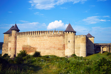Fototapeta na wymiar Wall of ancient stone castle with many hight towers in Khotyn, Ukraine on July 19, 2018. 