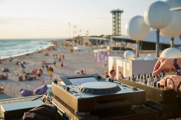 Dj's sound equipment and people on blurred background. Summer music festival on beach