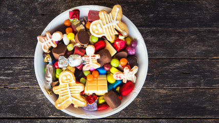 Halloween Jack o Lantern candy bowl with candy and halloween cookies Trick or Treat on old wooden background