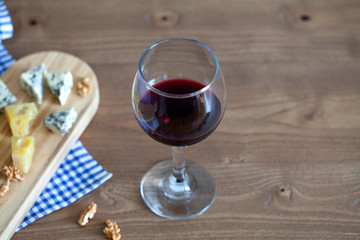 red wine with cheese over wooden table