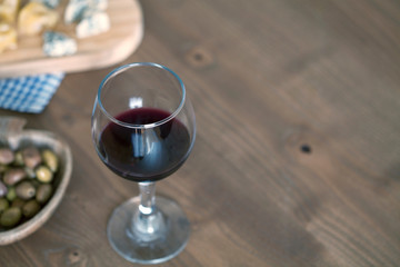 red wine with cheese over wooden table