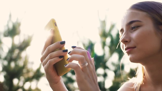 Face young woman use smartphone smile happy background sun tree summer technology cellphone chroma key working communication device display sun relaxation slow motion