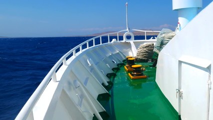 On the front deck of moving ferry boat with water splashing of the bow