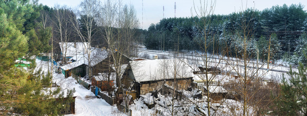 Winter rural landscape with snowy houses and pines
