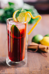 Orange lemonade in glass with fresh orange and mint over light grey stone table. Refreshing summer drink. Cocktail bar background concept. 