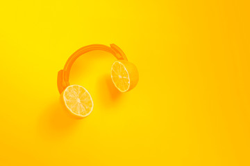 Yellow citrus headphones. Creative concept for summer parties.