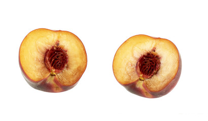 two halves of a ripe peach with a pit isolated on a white background