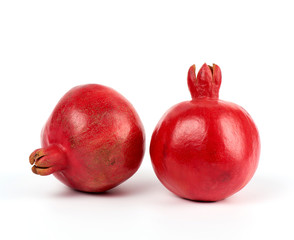 two ripe red pomegranates in a peel on a white background