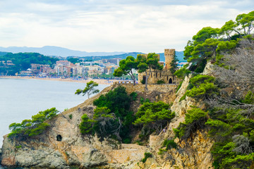 Picturesque view of Lloret de Mar and castle on the rock in cloudy weather, Costa Brava, Spain.