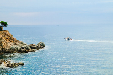 Mediterranean Sea bay in the vicinity of Lloret de Mar, Costa Brava with pleasure boat.