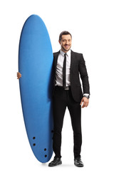 Young man in a suit holding a surfboard
