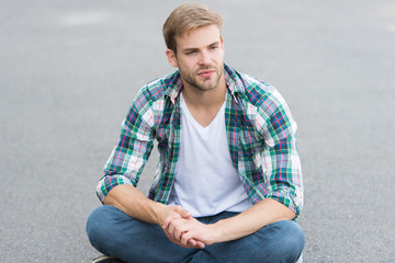 i have free time. male fashion. student relax on road. macho guy outdoor. street style. man sit ground. carefree student guy. free time spending. summer fashion. handsome man checkered shirt