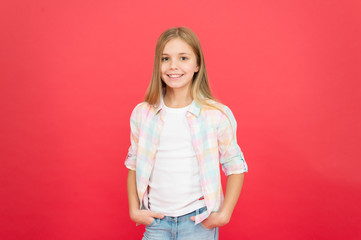 on style. kid fashion. stylish beauty. small girl red background. happy childhood. smiling blonde...