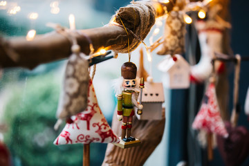 Decorative Christmas tree ornament. Hanging on tree branch, small white house, lead soldier, cloth...