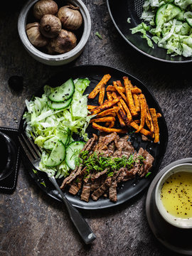 Black garlic seasoned skirt stake with sweet potato and iceberg cucumber salad