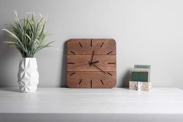 Interior. Office interior. Classic alarm clock and green grass in pot on gray background. Details of business interior.