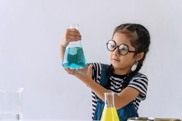Little 6s cute girl with microscope holding laboratory bottle with water experiment study...