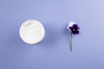 Body care products and flowers on a blue background