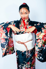young pretty real geisha in kimono with sakura and decoration on white background isolated