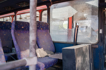Interior seats with broken windows of the wrecked bus car accident collision traffic after the...