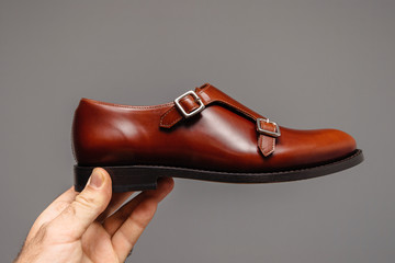 Man holding new luxury double hand-dyed and hand-polished leather surface with double-buckle monkstrap shoe