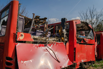 Disassembled bus after the accident used for parts wrecked broken red buses scrap for recycling
