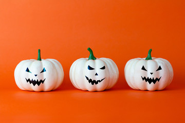 White ghost pumpkin on orange background with copy space ,  halloween concept.