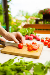Woman cutting slices of tomatoes.