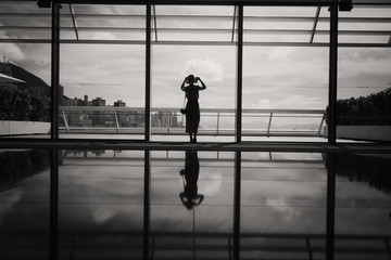 Fototapeta premium Woman stand in front of windows