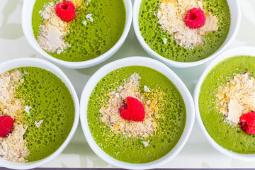 Green spinach smoothie on blue table top view.