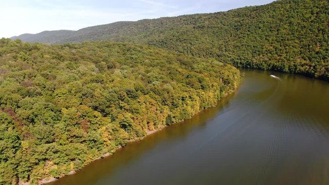 Aerial view of a motorboat in Raystown lake surrounded by the forest.