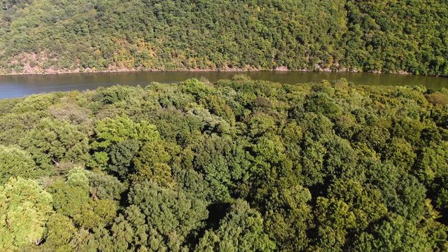 Aerial reveal shot of lake and motorboat in Raystown Lake, Pennsylvania, between two tree-covered mountain ridges