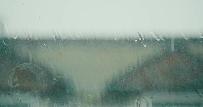 Rain drops falling on window during a storm. Shot in 4K RAW on a cinema camera.