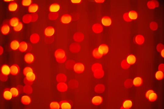 Red-orange trendy festive background of blurry Christmas lights