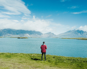 Fototapeta na wymiar The guy is enjoying the view on the endless mountains on Iceland