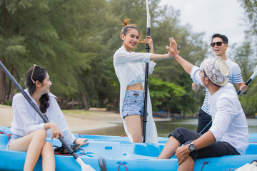 Young friends having fun and relax on Kayaks on the island of Thailand. Couple rowing in a kayak on...
