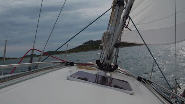 Sailboat making a tack turn. Skipper poit of view. Island in the background.
