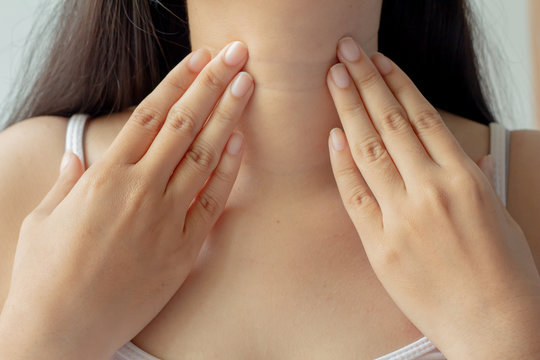 Close up female checking thyroid gland by herself or Sore throat or pain on neck.