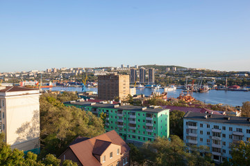 Vladivostok city in suset. Buildings, sea