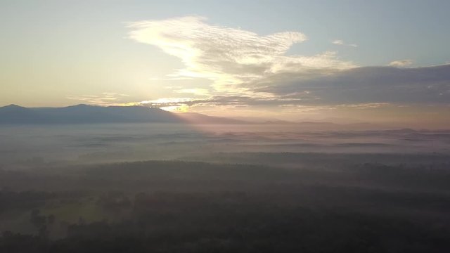 Aerial view sunray over the misty morning neae forest at MBI Desaku, Kulim, Kedah, Malaysia.