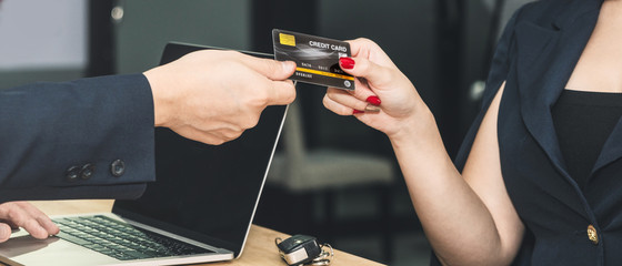 business background of businesswoman hand give credit card to man hand to make payment on service and product