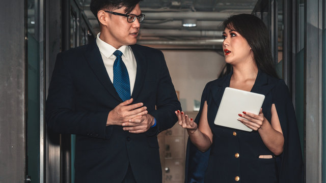 business background of businessman and businesswoman having business discussion while walking in office