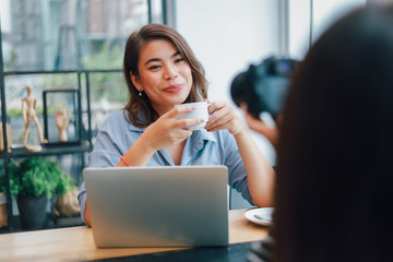 Asian woman in blue shirt  in cafe drinking coffee and talking with boy friend smile and happy face