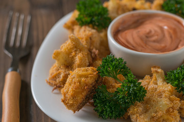 Baked cauliflower with the sauce and a fork on the table.