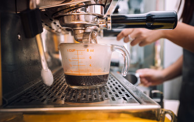 Fototapeta na wymiar Barista using coffee machine for making coffee in the cafe, Coffee Preparation Service Concept