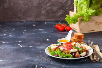 Healthy food - vegetables and salmon salad on a dark background. Selective focus. Copy space