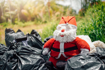 Santa Claus doll is dumped in a dump. garbage.