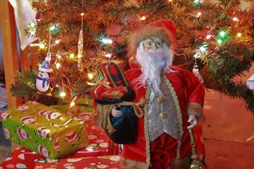 Santa Claus with Christmas gifts under the Christmas Tree