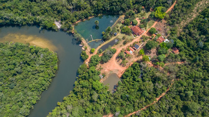 Fototapeta na wymiar Aerial view of an meandering Amazon tributary river and buildings in the Amazonian rainforest, Mato Grosso, Brazil