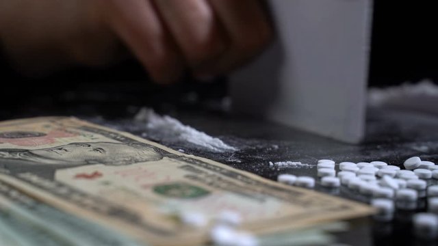 White cocaine powder on a table with dollar bills